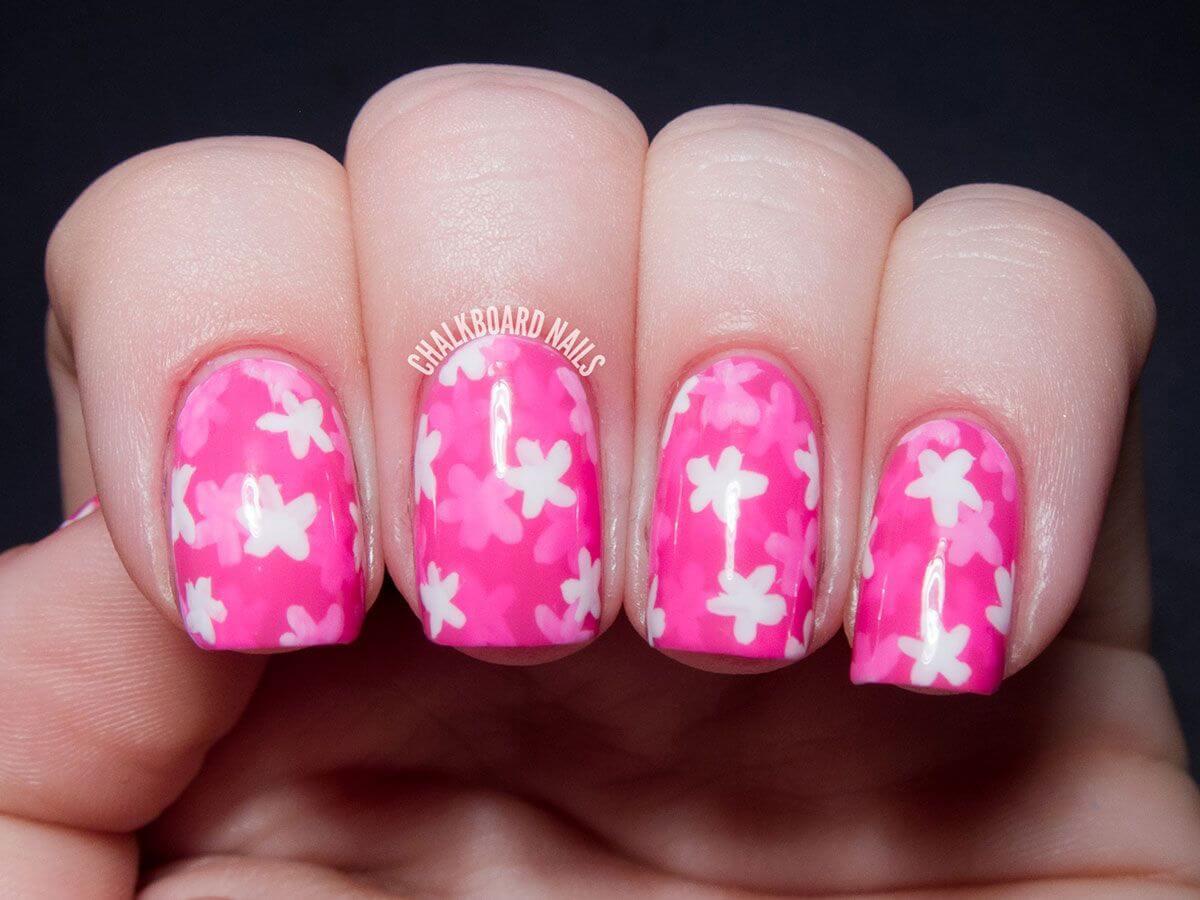 Ongles roses avec fleurs blanches
