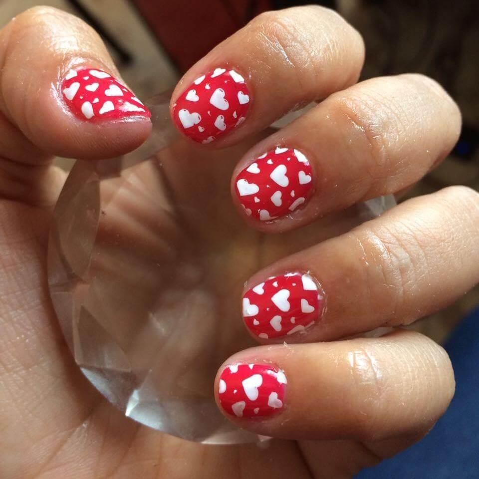 ongles rouges avec coeurs blancs